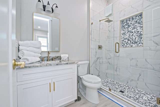 bathroom featuring hardwood / wood-style flooring, vanity, toilet, and a shower with shower door