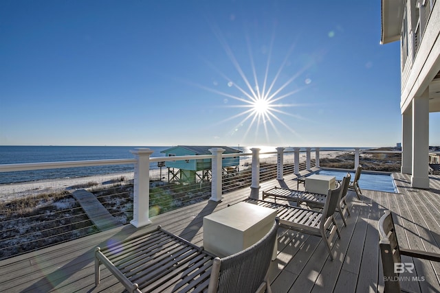 deck with a view of the beach and a water view