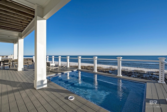 view of swimming pool with a view of the beach and a water view