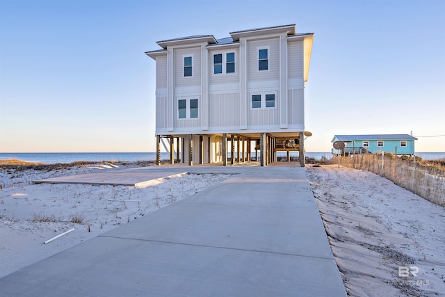 view of front of house featuring a carport, a water view, and a view of the beach