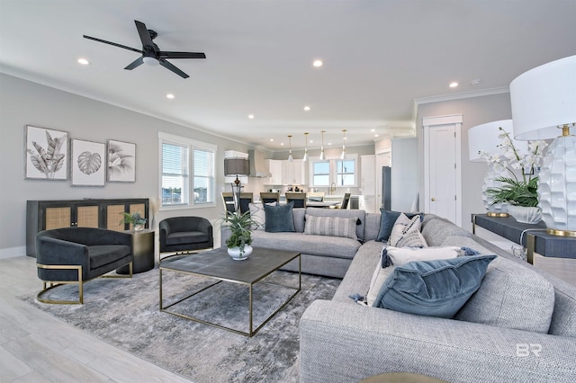 living room featuring crown molding, light hardwood / wood-style floors, and ceiling fan