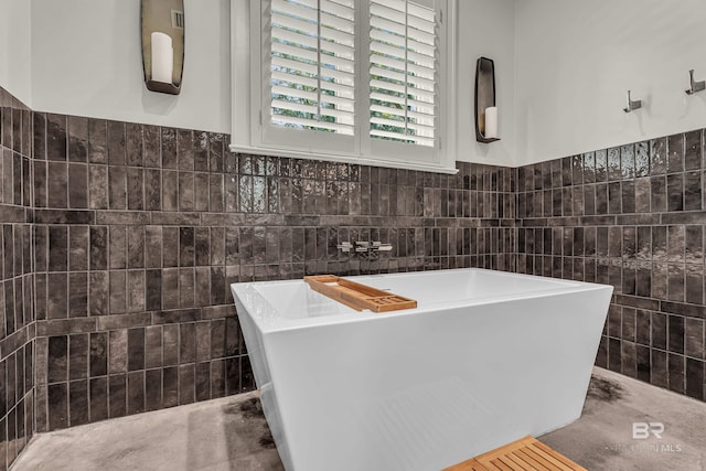 full bathroom with tile walls and a freestanding tub