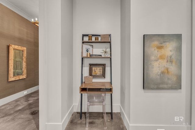 hallway with concrete flooring and baseboards