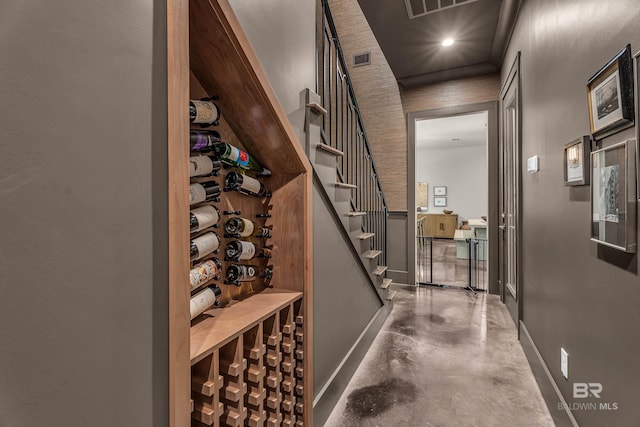 wine room featuring concrete flooring and baseboards