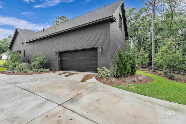 view of side of home with brick siding, concrete driveway, and a garage