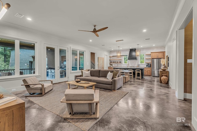 living area featuring ceiling fan, finished concrete floors, recessed lighting, and ornamental molding