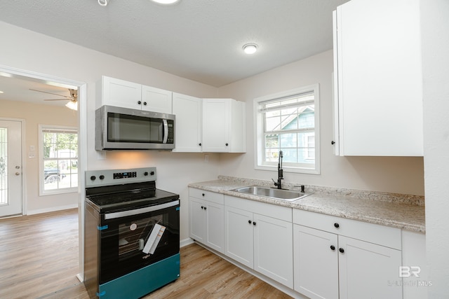 kitchen featuring white cabinets, light hardwood / wood-style floors, sink, and stainless steel appliances