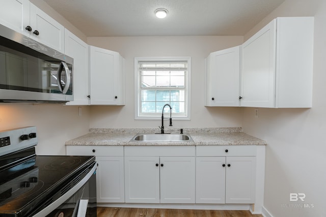 kitchen featuring sink, white cabinets, and appliances with stainless steel finishes