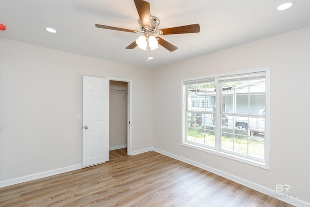 unfurnished bedroom with ceiling fan, a closet, and light hardwood / wood-style flooring