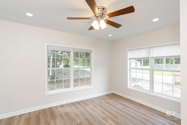 empty room featuring light hardwood / wood-style flooring, plenty of natural light, and ceiling fan