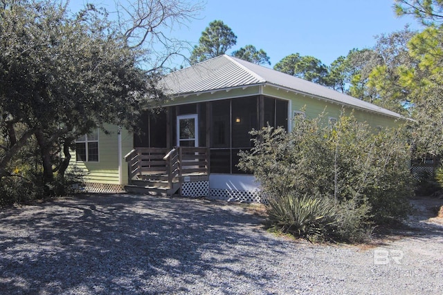 view of front of house featuring metal roof and a sunroom