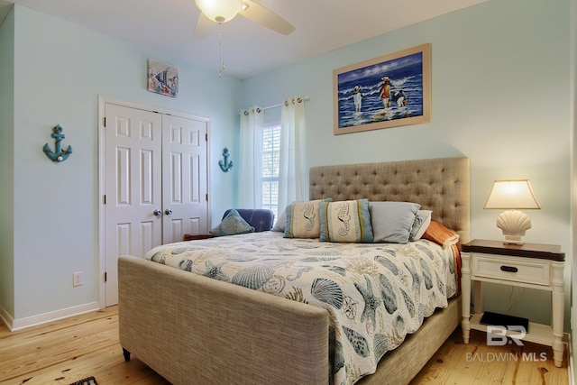 bedroom featuring a ceiling fan, a closet, baseboards, and wood finished floors