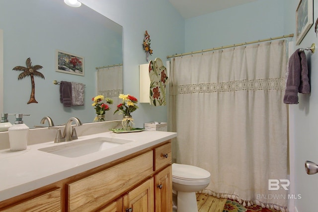 bathroom featuring wood finished floors, vanity, toilet, and a shower with curtain