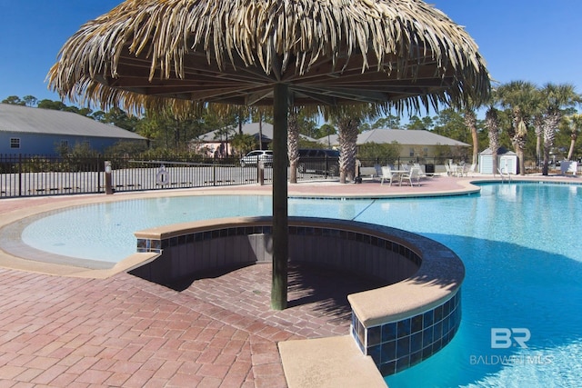 pool featuring a patio area, fence, and a hot tub