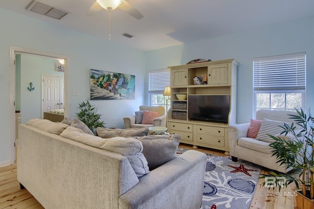 living room with a wealth of natural light, light wood-type flooring, and visible vents