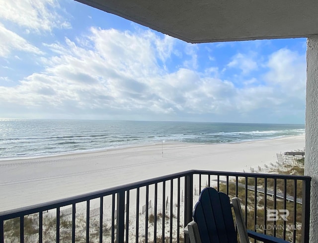 balcony featuring a water view and a view of the beach