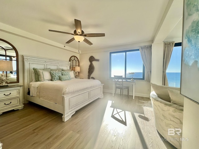 bedroom featuring a water view, ceiling fan, and light wood-type flooring