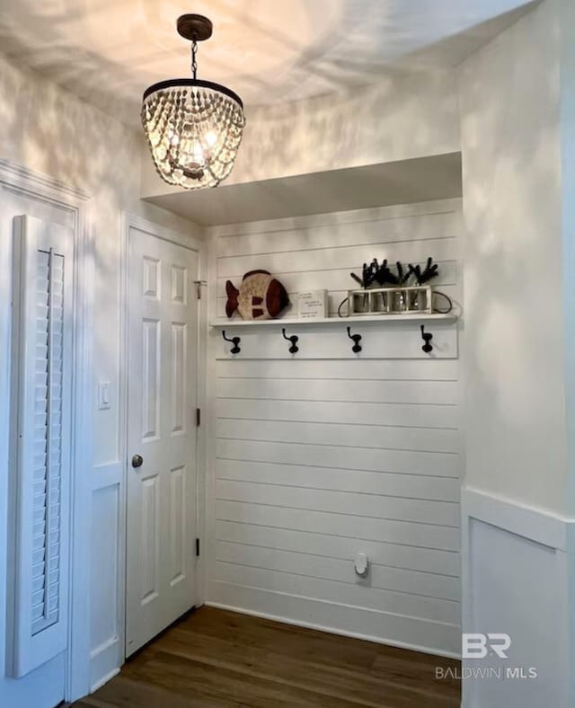 mudroom with dark wood-type flooring and a notable chandelier