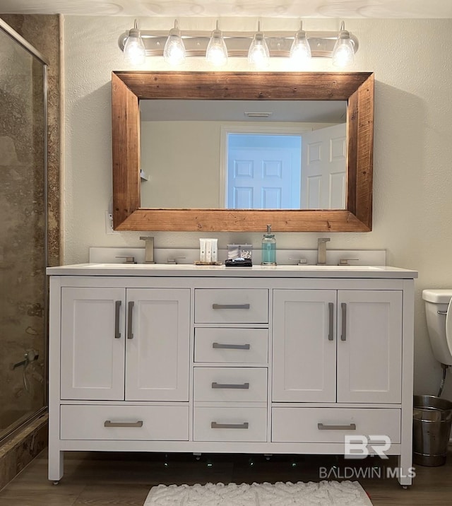 bathroom with vanity, toilet, and an enclosed shower