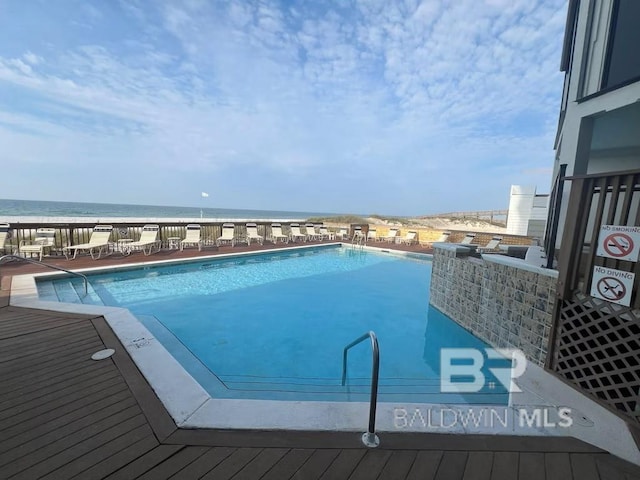 view of swimming pool with a view of the beach and a water view