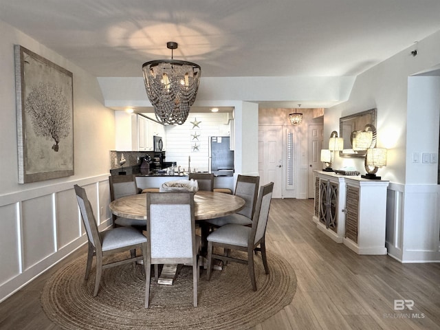 dining room with hardwood / wood-style floors and a chandelier