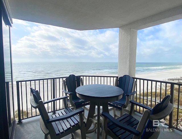 balcony featuring a water view and a beach view