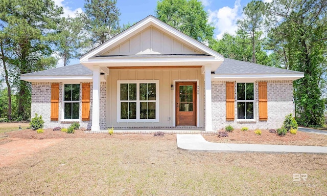 view of front of property with brick siding, a shingled roof, and board and batten siding