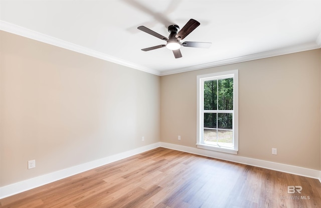 spare room featuring a ceiling fan, baseboards, ornamental molding, and light wood-style flooring