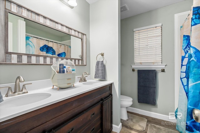 bathroom featuring vanity, hardwood / wood-style flooring, and toilet