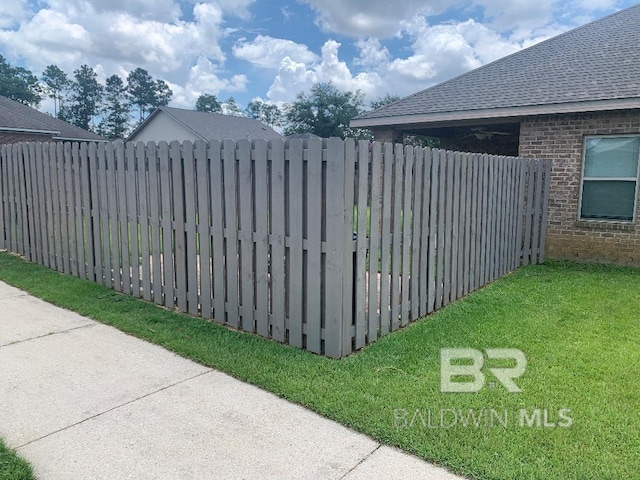 view of gate with a lawn