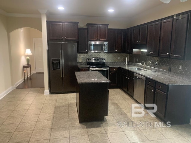 kitchen featuring light tile patterned floors, backsplash, appliances with stainless steel finishes, sink, and ornamental molding