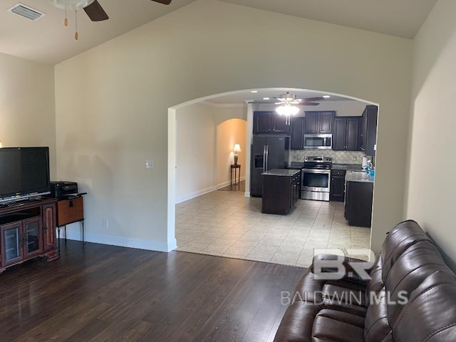 living room with lofted ceiling, ceiling fan, and light wood-type flooring