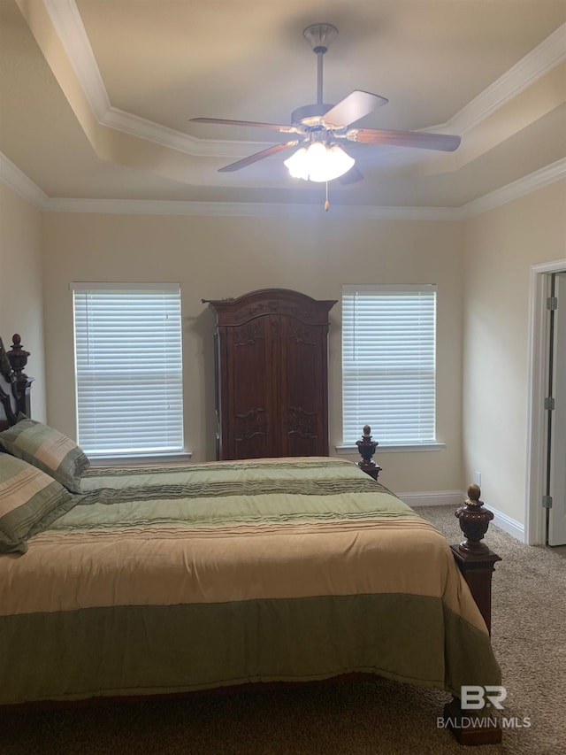 carpeted bedroom featuring ceiling fan, a raised ceiling, and ornamental molding