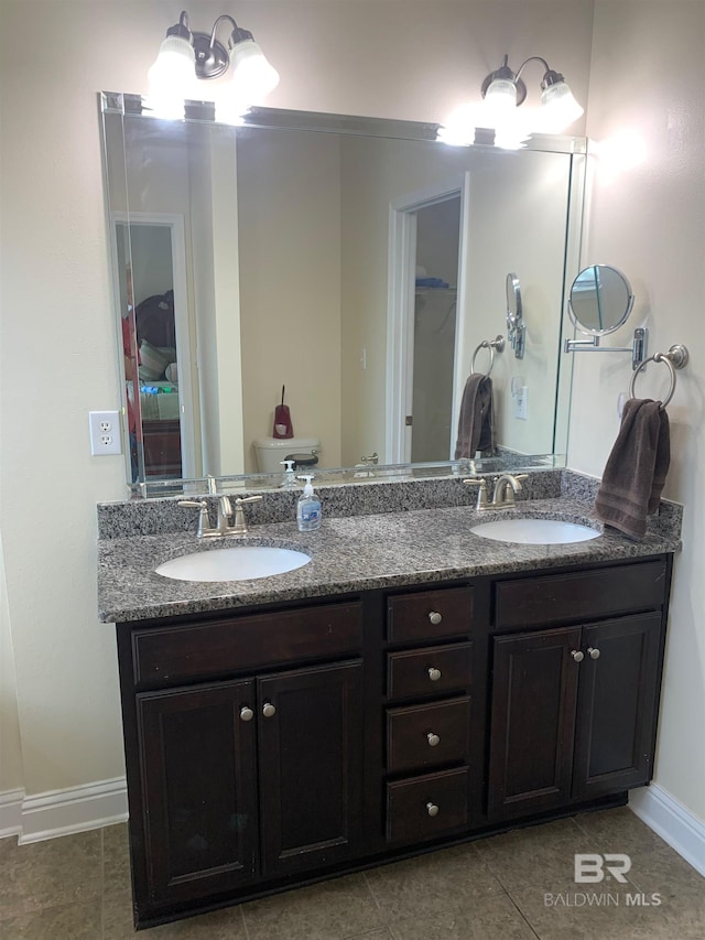 bathroom with toilet, tile patterned flooring, and double vanity