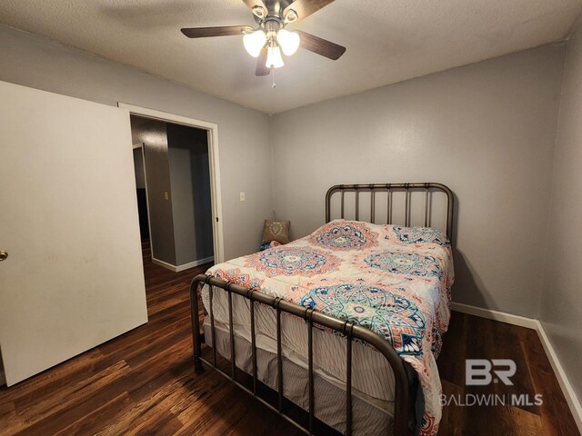 bedroom featuring a textured ceiling, ceiling fan, and dark hardwood / wood-style floors