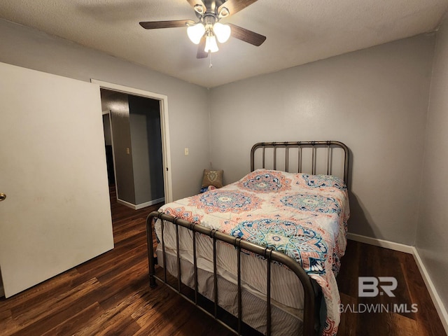 bedroom featuring a ceiling fan, a textured ceiling, baseboards, and wood finished floors