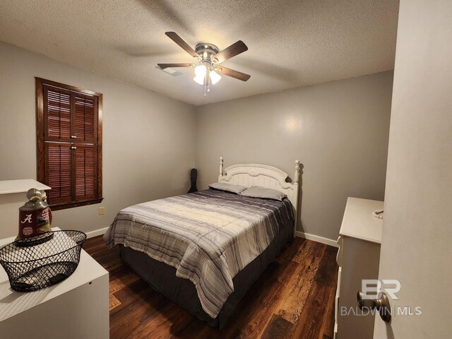 bedroom with dark hardwood / wood-style floors, a textured ceiling, and ceiling fan