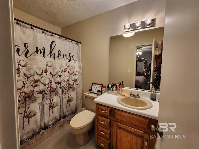 bathroom featuring vanity, a textured ceiling, toilet, and tile patterned flooring