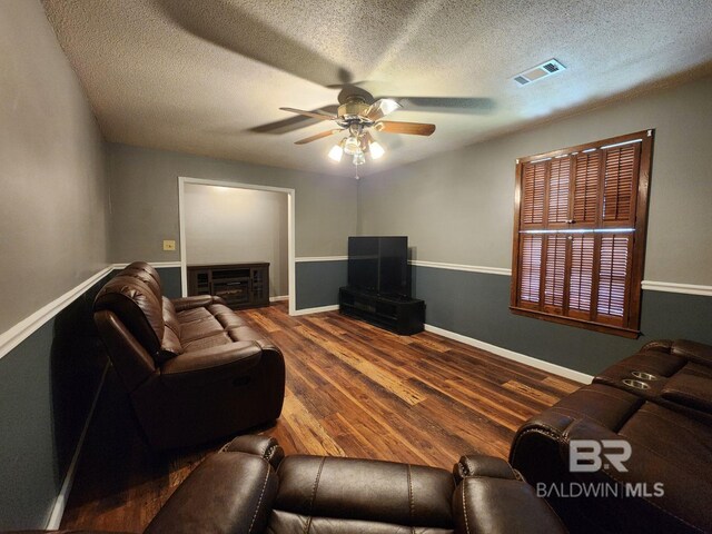 living room with ceiling fan, hardwood / wood-style floors, and a textured ceiling