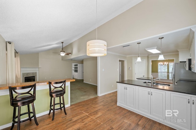 7750 Charleston Oaks Dr, Daphne, AL 36526 - kitchen featuring dark countertops, a sink, white appliances, a peninsula, and lofted ceiling