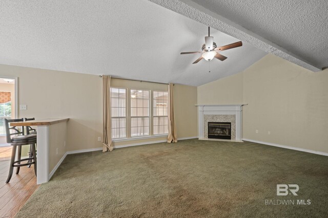 7750 Charleston Oaks Dr, Daphne, AL 36526 - unfurnished living room with carpet floors, ceiling fan, a textured ceiling, vaulted ceiling, and a premium fireplace