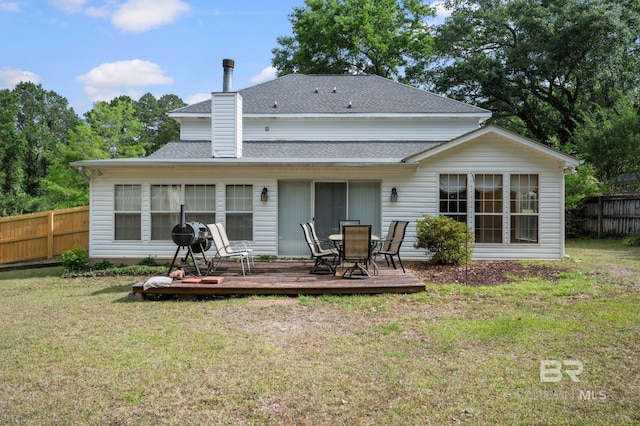 7750 Charleston Oaks Dr, Daphne, AL 36526 - rear view of property featuring fence, roof with shingles, a wooden deck, a chimney, and a lawn