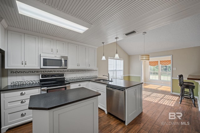 7750 Charleston Oaks Dr, Daphne, AL 36526 - kitchen featuring dark countertops, appliances with stainless steel finishes, a sink, a peninsula, and visible vents