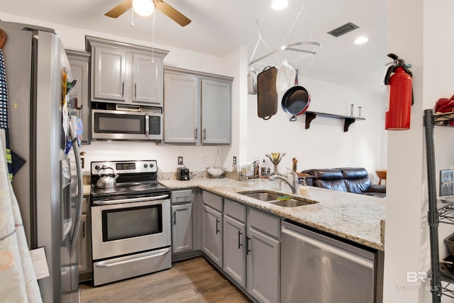 kitchen with ceiling fan, sink, light hardwood / wood-style flooring, gray cabinets, and appliances with stainless steel finishes