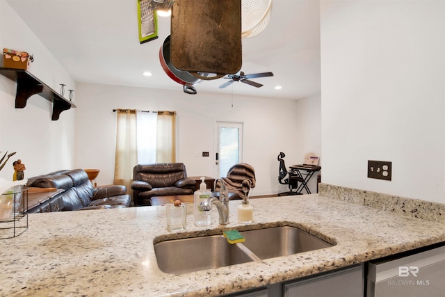 kitchen with light stone countertops, stainless steel dishwasher, ceiling fan, and sink