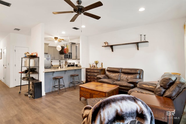 living room with light wood-type flooring and ceiling fan