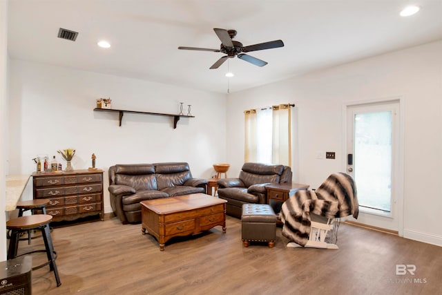 living room with light wood-type flooring and ceiling fan