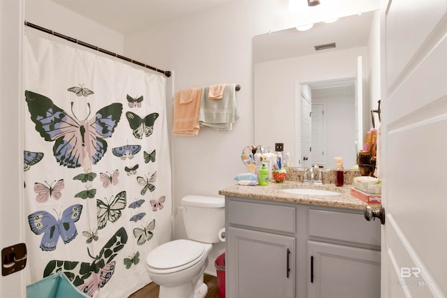 bathroom featuring curtained shower, vanity, and toilet