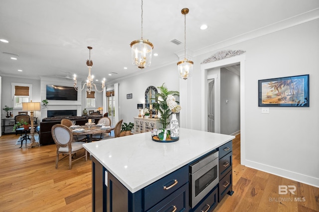 kitchen with light wood-type flooring, blue cabinets, stainless steel microwave, and crown molding