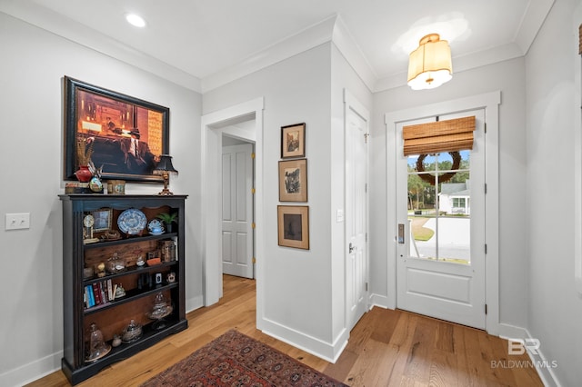 entrance foyer with light hardwood / wood-style floors and crown molding